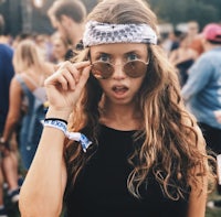 a girl wearing a bandana and sunglasses at a music festival